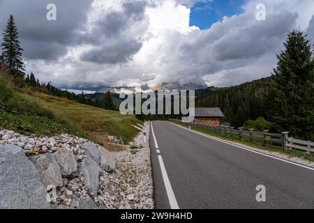 Une vue sur une route de montagne sinueuse près du col de Campolongo dans les Dolomites du Tyrol du Sud, Italie Banque D'Images