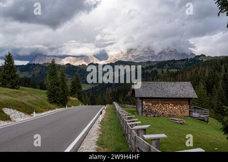 Une vue sur une route de montagne sinueuse près du col de Campolongo dans les Dolomites du Tyrol du Sud, Italie Banque D'Images