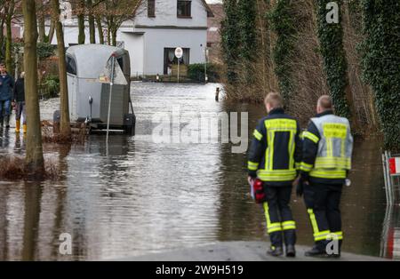 Lilienthal, Allemagne. 28 décembre 2023. Les pompiers se tiennent dans une rue résidentielle inondée du Wörpe. L'inondation de la rivière et du Wümme voisin a causé une brèche dans la digue pendant la nuit. Crédit : Focke Strangmann/dpa/Alamy Live News Banque D'Images