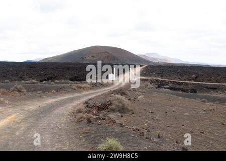 Route de campagne dans un paysage volcanique dans le parc national de Los Ajaches près de Papgayo. Playa Blanca, Lanzarote, Espagne Banque D'Images