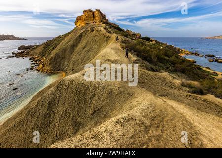 Baie de Għajn Tuffieħa avec il-Qarraba Rock. Plage de sable sombre, populaire pour le surf et situé dans une baie adossée à des collines, avec un sentier côtier près de L-Imġarr, Malte Banque D'Images