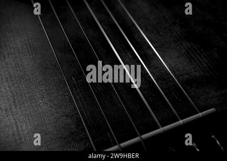 Gros plan sur les cordes de guitare classique et le pont dans Black and White Shadows Light Abstract Banque D'Images