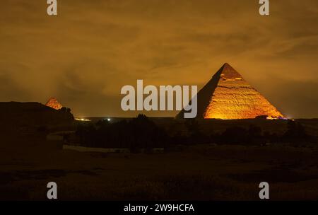 La pyramide de Cheops de Gizeh la nuit. Pyramide de Gizeh illuminée la nuit, vue du toit d'un hôtel. Pyramide de Khufu. Photo de voyage, personne, copys Banque D'Images