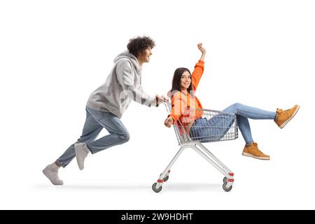 Guy courant et poussant une jeune femme heureuse à l'intérieur d'un panier isolé sur fond blanc Banque D'Images