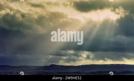 Glasgow, Écosse, Royaume-Uni. 28 décembre 2023. UK Météo : tempête Gerrit a fait pour une journée sombre et venteuse humide comme ciel orageux et rayons de soleil, rayons de dieu ou rayons crépusculaires sont apparus au-dessus de l'Écosse. Crédit Gerard Ferry/Alamy Live News Banque D'Images