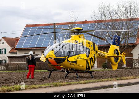 Stettenhofen, Bavière, Allemagne - 28 décembre 2023: hélicoptère de sauvetage Christoph 40 de l'ADAC Luftrettung atterrit dans une zone résidentielle lors d'une mission du médecin urgentiste dans le village de Langweid OT Stettenhofen *** Rettungshubschrauber Christoph 40 der ADAC Luftrettung Landet BEI einem Einsatz vom Notarzt im Dorf Langweid OT Stettenhofen in einer Wohnsiedlung Banque D'Images