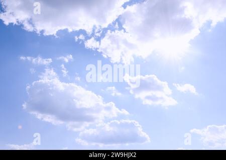 Le ciel bleu orné de beaux nuages filtrant la lumière du soleil, créant une scène fascinante dans la toile céleste Banque D'Images