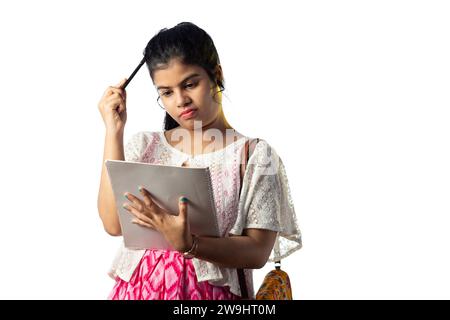 Une jolie jeune fille indienne pensant tout en prenant des notes et grattant la tête sur fond blanc Banque D'Images