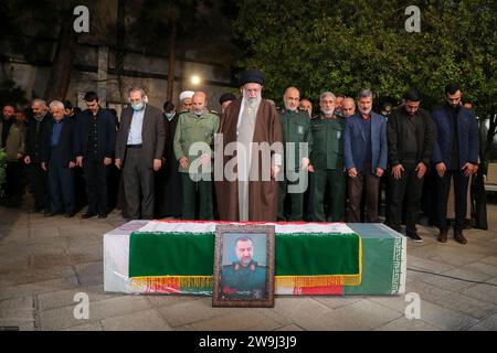 Téhéran, Iran. 28 décembre 2023. Le guide suprême iranien, l'ayatollah ALI KHAMENEI (C), priant à côté du cercueil du conseiller militaire du corps des gardiens de la révolution islamique iranien (CGRI), Seyed Razi Mousavi, commandant en chef de la Force Qods du corps des gardiens de la révolution islamique (CGRI), tué le 25 décembre lors d'une frappe israélienne en Syrie, à Téhéran. (Image de crédit : © Bureau du leader suprême iranien via ZUMA Press Wire) USAGE ÉDITORIAL SEULEMENT! Non destiné à UN USAGE commercial ! Banque D'Images