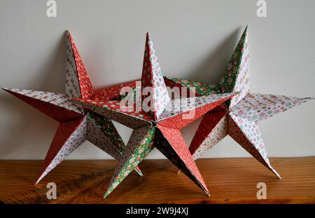 Un trio d'étoiles origami faites à la main sur un fond blanc Banque D'Images
