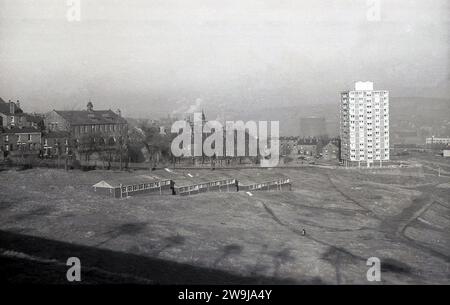 Années 1970, historique, vue depuis le sommet d'une colline à Sheffield, une ville sidérurgique et industrielle dans le South Yorkshire, Angleterre, Royaume-Uni, montrant un bloc de tour moderne d'appartements de grande hauteur se détachant sur le paysage urbain sombre. Banque D'Images