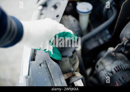 Vérification du niveau d'antigel dans le liquide de refroidissement dans la voiture, bouchons de radiateur haute pression, réparation de voiture Banque D'Images