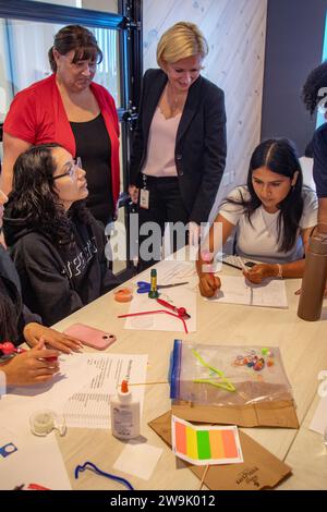 Un enseignant encourage les étudiants multiraciaux à expérimenter avec des dispositifs de technologie médicale dans une semina de démonstration de l'installation medtech d'Irvine, Californie Banque D'Images