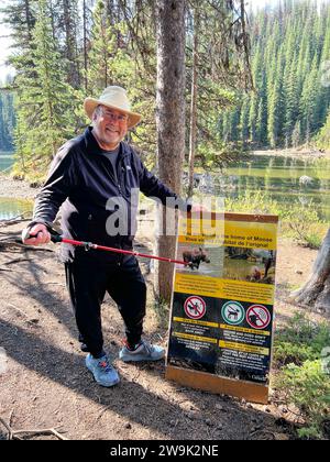 Jasper, AB Canada - 26 mai 2023 : un homme à côté d'un panneau lors d'une randonnée nature à Moose Lake près de Jasper, Alberta au Canada Parc national Jasper sur un terrain ensoleillé Banque D'Images