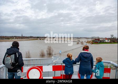On voit des gens regarder un des escaliers déjà inondés par la rivière Waal. Les jours pluvieux de Noël ont causé des désagréments importants dans tout le pays-Bas. À Nimègue, les parties basses du quai et autour du port de la Waalkade sont sous l'eau. Le niveau d'eau en ce moment est d'environ 14,60 mètres au-dessus de NAP. (Normaal Amsterdams Peil) la NAP est la base utilisée pour mesurer le niveau d'eau élevé ou bas. Comme il pleut encore beaucoup aux pays-Bas, il y a de fortes chances que le niveau de l’eau augmente à nouveau au début de la nouvelle année. Banque D'Images