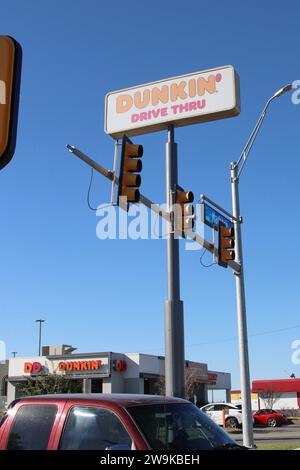 Vue extérieure et signalisation d'un emplacement Dunkin' Donuts à San Antonio, Texas, États-Unis, le 28 décembre 2023. Fondée en 1948, Dunkin' Donuts compte actuellement environ 12 900 sites dans 42 pays. En 2020, la société a été rachetée par inspire Brands. Inspire Brands LLC est propriétaire et franchiseur des chaînes de restaurants Arby's, Buffalo Wild Wings, Sonic Drive-In, Jimmy John's, Mister Donut et Baskin-Robbins. Inspire Brands appartient à Roark Capital Group. Roark Capital est une société américaine de capital-investissement avec environ 37 milliards d'actifs sous gestion. La société de capital-investissement porte le nom de Ho Banque D'Images