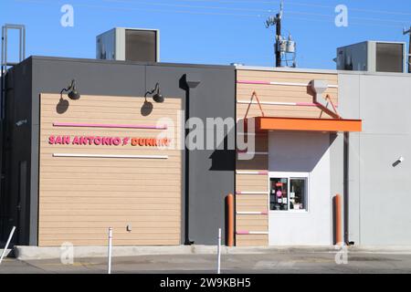 Vue extérieure et signalisation d'un emplacement Dunkin' Donuts à San Antonio, Texas, États-Unis, le 28 décembre 2023. Fondée en 1948, Dunkin' Donuts compte actuellement environ 12 900 sites dans 42 pays. En 2020, la société a été rachetée par inspire Brands. Inspire Brands LLC est propriétaire et franchiseur des chaînes de restaurants Arby's, Buffalo Wild Wings, Sonic Drive-In, Jimmy John's, Mister Donut et Baskin-Robbins. Inspire Brands appartient à Roark Capital Group. Roark Capital est une société américaine de capital-investissement avec environ 37 milliards d'actifs sous gestion. La société de capital-investissement porte le nom de Ho Banque D'Images