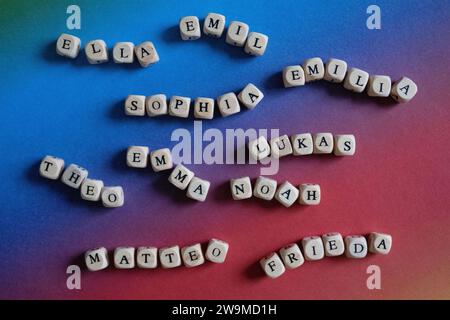 Stuttgart, Allemagne. 28 décembre 2023. Cubes en bois avec des lettres qui composent Ella, Emil, Sophia, Emilia, Théo, Emma, Lukas, Noah, Matteo et Frieda sont couchés sur un carton coloré sur une table. Comme l’année précédente, les prénoms les plus populaires en 2023 sont Emilia et Noé. C’est selon un aperçu publié vendredi par l’expert en noms nord-allemand Knud Bielefeld. Les autres noms dans le classement sont Emma et Sophia pour les filles et Matteo et Elias pour les garçons. Crédit : Marijan Murat/dpa/Alamy Live News Banque D'Images