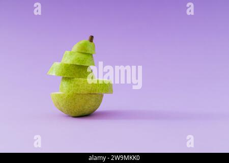 Composition créative de fruits faite avec des tranches de poire empilées fraîches sur fond violet pastel. Disposition minimale. Concept nature. Esthétique poire. Banque D'Images