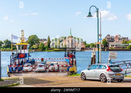 Le ferry en provenance de Krimpen aan de Lek accoste à l'embarcadère de Kinderdijk, aux pays-Bas, avec des passagers en voiture, scooter et vélo. Banque D'Images