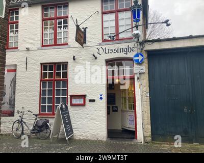 Dans une rue calme près du centre de Bruges, en Belgique, un piéton pourrait même manquer café Vlissinghe, sur une photo du 21 décembre 2023. Mais ceux qui découvrent l’entrée du petit café de la Blekersstraat se retrouveront dans un voyage dans le temps. Le café est le plus ancien établissement de ce type à Bruges et l'un des plus anciens au monde. Il est en opération depuis 1515, selon les archives de la mairie locale. Il a donc récemment célébré son 500e anniversaire et, comme le disent les habitants, a survécu aux guerres et aux révolutions. Dans le passé, il a été visité par des artistes célèbres tels que les Flamands Banque D'Images