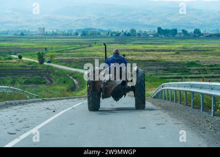Vieil homme, conduisant un tracteur, sur la route. Paysage. Campagne. Décor. 5. 8. 2023 Sokolarci. Macédoine Banque D'Images