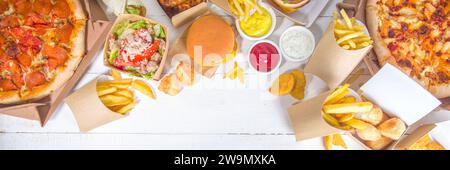 Livraison fastfood commande de nourriture en ligne concept. Grand assortiment de plats à emporter pizza, frites, nuggets de poulet frits, hamburgers, salades, chic Banque D'Images