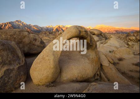 L'est de la Sierra Nevada est illuminé au lever du soleil avec l'Arche Mobius au premier plan dans les collines de l'Alabama, CA. Banque D'Images