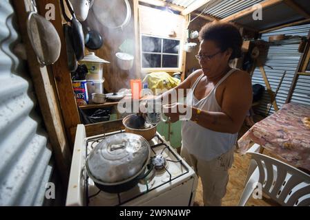 Une femme Kalinago prépare du thé frais à la citronnelle chez elle dans le territoire de Kalinago sur l'île caribéenne de la Dominique. Banque D'Images