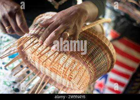 Une femme tisse un panier traditionnel dans le village du patrimoine de Touna Kalinago, dans le territoire de Kalinago, sur l’île caribéenne de la Dominique. Banque D'Images