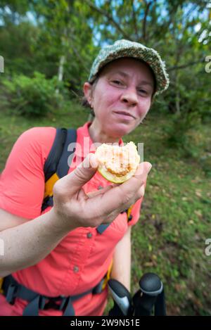 Une femme profite d’une goyave fraîche cueillie dans un arbre du quartier français sur le segment 1 du sentier national Waitukubuli sur l’île caribéenne de la Dominique. Banque D'Images