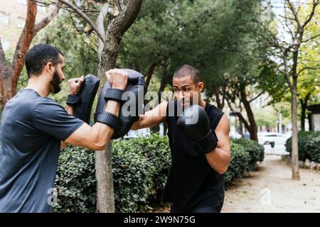 Deux hommes se battant avec des gants dans un parc Banque D'Images