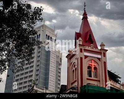 Nuages noirs dramatiques du soir au-dessus de l'église méthodiste Bowen Memorial (r) à Colaba, Mumbai, Inde, construite en 1887 en l'honneur du missionnaire George Bowen Banque D'Images