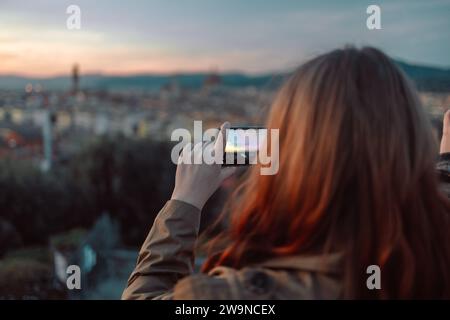 Femme Prenez une photo du coucher de soleil doré sur le Palazzo Vecchio et la cathédrale de Santa Maria del Fiore (Duomo), Florence, Italie Banque D'Images