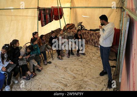 Rafah. 28 décembre 2023. Des étudiants étudient dans une salle de classe temporaire dans la ville de Rafah, dans le sud de la bande de Gaza, 28 décembre 2023. Certains étudiants de Gaza sont passés étudier dans des salles de classe temporaires car de nombreuses écoles sont utilisées ici pour accueillir les sans-abri infligés par une nouvelle vague de conflit israélo-palestinien. Crédit : Rizek Abdeljawad/Xinhua/Alamy Live News Banque D'Images