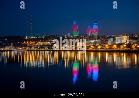 Vue de nuit sur la ligne d'horizon de Bakou, capitale de l'Azerbaïdjan avec reflet des tours de flamme dans les eaux de la mer Caspienne. Banque D'Images