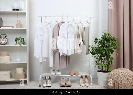 Rack avec différents vêtements et chaussures élégants pour femmes à l'intérieur Banque D'Images