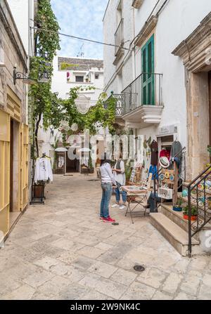 Locorotondo, Pouilles, Italie - 5 octobre 2023 : rue étroite caractéristique dans le Locorotondo, ville métropolitaine de Bari dans les Pouilles. Banque D'Images