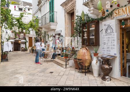 Locorotondo, Pouilles, Italie - 5 octobre 2023 : rue étroite caractéristique dans le Locorotondo, ville métropolitaine de Bari dans les Pouilles. Banque D'Images