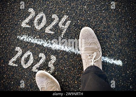 FOTOMONTAGE, Schuhe stehen auf der Schwelle zwischen 2023 und 2024, Symbolfoto Jahreswechsel *** FOTOMONTAGE, Chaussures debout sur le seuil entre 2023 et 2024, photo symbolique tournant de l'année Banque D'Images
