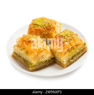 Baklava avec pistaches, 3 pièces, sur une plaque blanche, isolé, vue de côté Banque D'Images