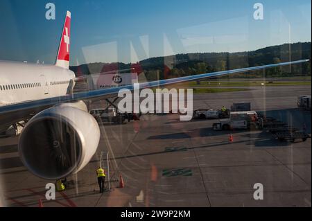 26.05.2017, Zuerich, Schweiz, Europa - Flugpassiere steigen fruehmorgens aus einem geparkten Passagierflugzeug der Swiss International Air Lines vom Typ Boeing 777-300ER aus, welches am Dock E terminal des Flughafen Zuerich-Kloten geparkt ist. Swiss ist Mitglied der Star Alliance Luftfahrtallianz, einem internationalen Netzwerk von Fluggesellschaften. *** 26 05 2017, Zurich, Suisse, Europe les passagers débarquent tôt le matin d'un Boeing 777 300ER stationné à Swiss International Air Lines au terminal Dock E de l'aéroport Zurich Kloten Swiss est membre Banque D'Images