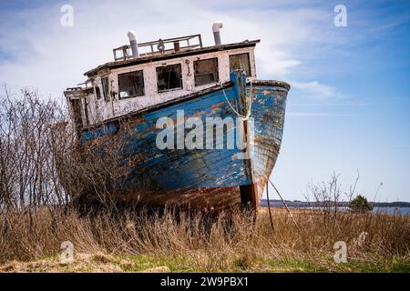 Bateau de pêche en bois abandonné pourrissant lentement sur la côte est de la Nouvelle-Écosse, Canada. Banque D'Images