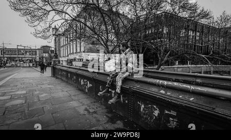 Un punk solitaire se détend sur le Lockside Bridge à Camden à Noël. Banque D'Images