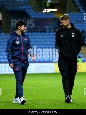 Kyle McFadzean de Coventry City (à droite) parle à Liam Walsh de Swansea City sur le terrain avant le match du championnat Sky Bet au Coventry Building Society Arena, Coventry. Date de la photo : Vendredi 29 décembre 2023. Banque D'Images