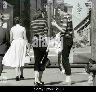 Deux femmes en chandails rayés discutant sur un coin de trottoir, près de 41st Street, New York City, New York, USA, Angelo Rizzuto, Anthony Angel Collection, août 1956 Banque D'Images