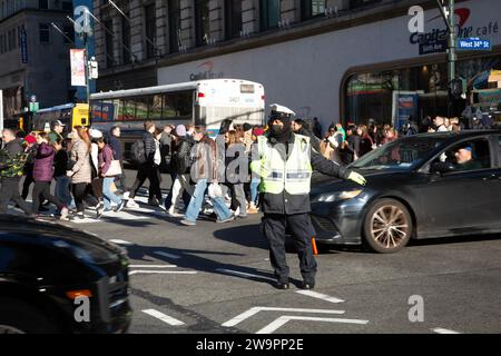 L'officier de trafic de NYPD dirige la circulation au coin toujours occupé de Broadway et 34th Street à Manhattan pendant la saison des vacances de Noël. Banque D'Images