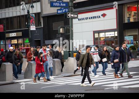 Le coin toujours animé de la 5e Avenue et de la 34e rue à Manhattan pendant la saison des vacances de Noël. Banque D'Images