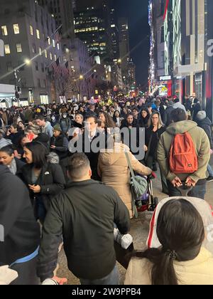 Des milliers de personnes emballent la 5th Avenue près du Rockefeller Center une semaine avant Noël pour voir le géant sapin de Noël Rockefeller, magasiner et regarder dans les décorations le long de la rue dans les vitrines des magasins. Banque D'Images