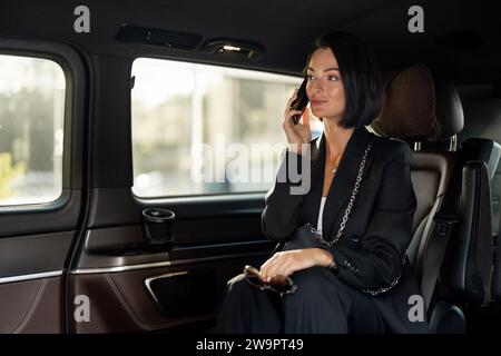 Femme d'affaires avec téléphone dans la voiture Banque D'Images